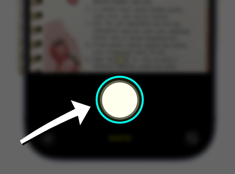 The Camera app with the shutter button highlighted above a cookbook page